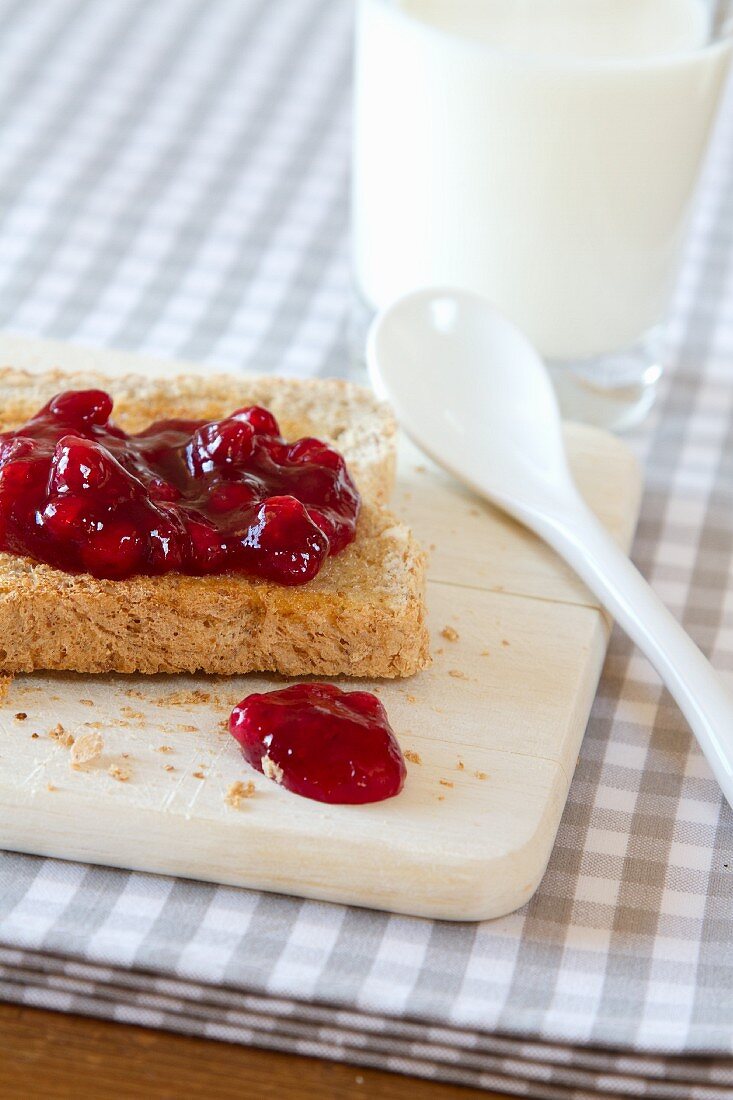 Toast with fresh cherry jam, served with a glass of milk