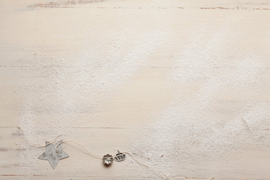 Icing sugar and Christmassy decorations on a wooden surface