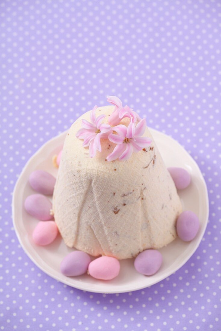 Pashka (Quarkdessert, Polen) mit rosa Blüten und Marzipaneiern zu Ostern