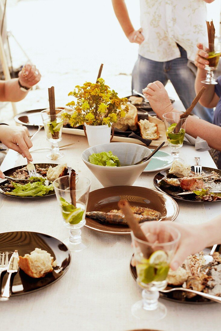 Gedeckter Tisch mit Grillfisch, Salat und Brot