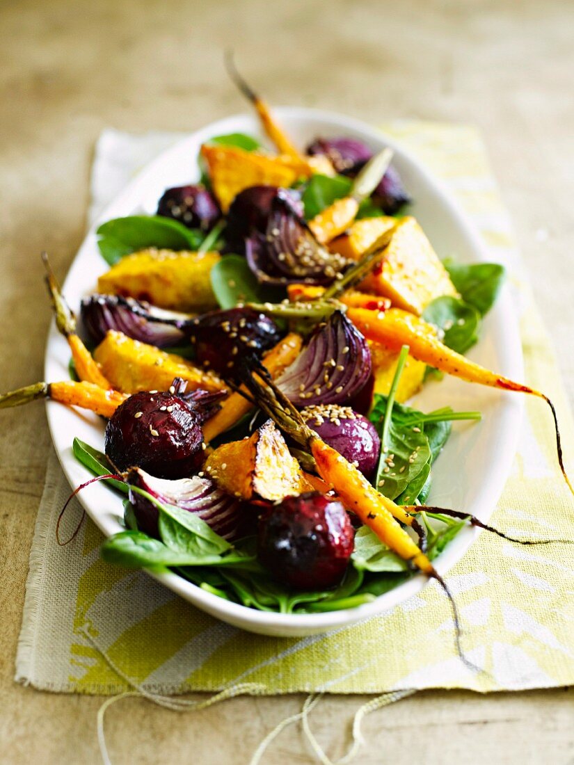 Warm root vegetable salad made with carrots, pumpkin, beetroot and onions