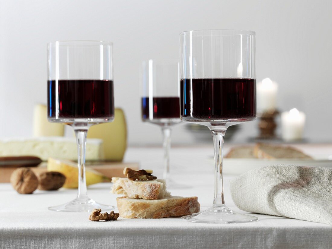 Glasses of red wine in front of a cheeseboard with bread