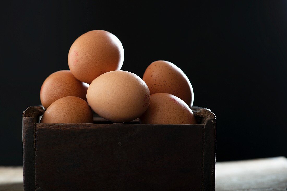 Fresh brown eggs in a wooden box