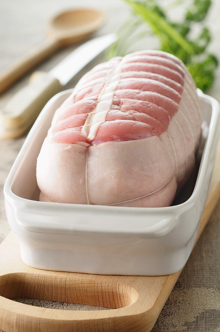 Raw rolled joint of veal wrapped in bacon