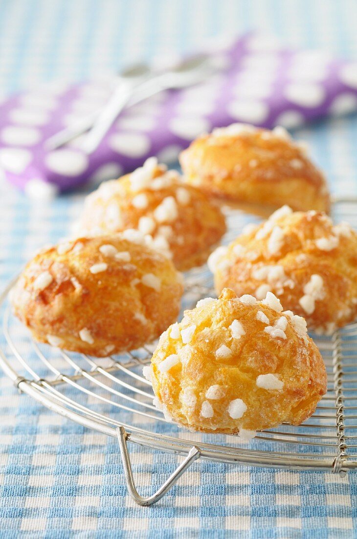 Chouquettes with sugar crystals on a cooling rack