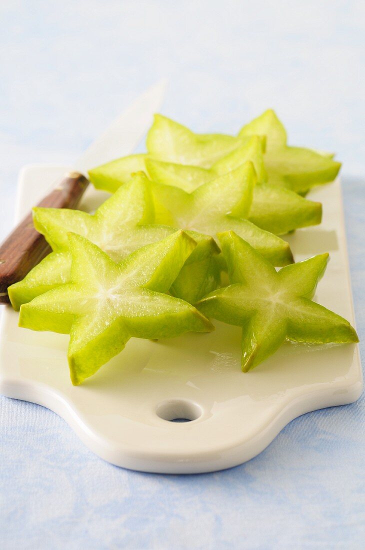 Lots of starfruit slices on a chopping board