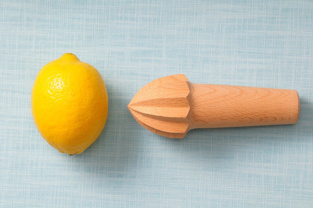 A lemon and a lemon squeezer on a wooden surface