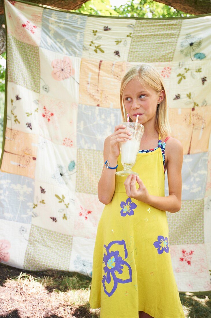 A Young Girl Drinking a Milkshake Outdoors