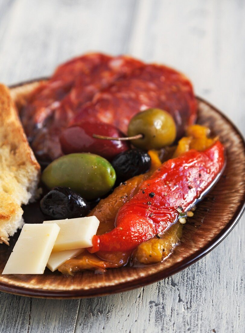 Antipasto with Fire Roasted Red and Yellow Peppers, Mixed Olives, Provolone Cheese, Sopressata and Italian Bread