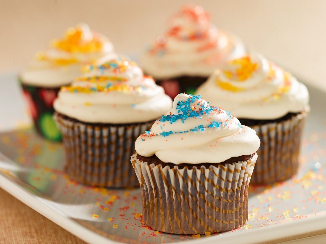 Chocolate Cupcakes with Vanilla Frosting and Colored Sugar Crystals; On a Platter
