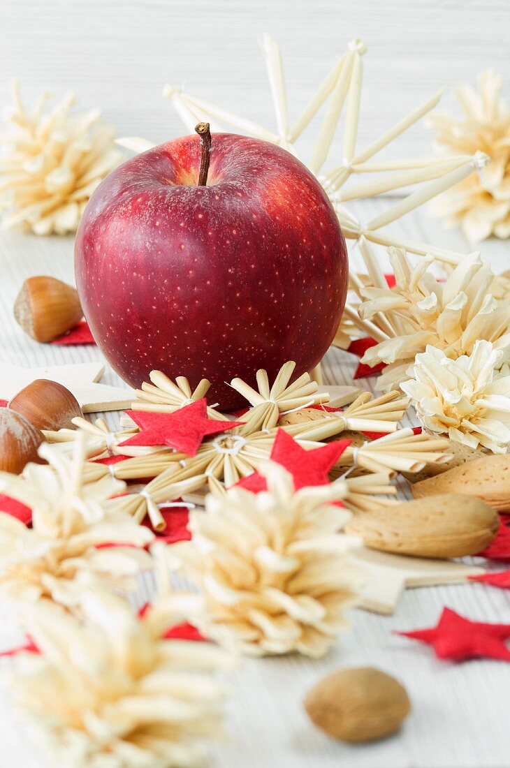 Weihnachtsdekoration mit Apfel Nüssen und Strohsternen