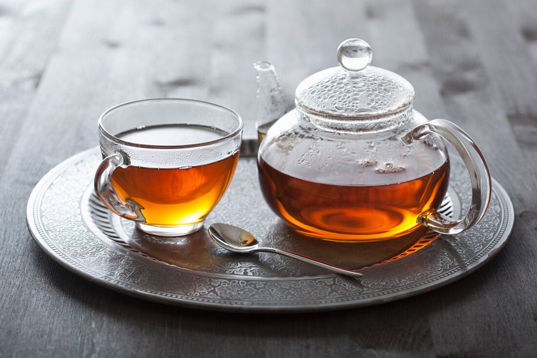 Tea in glass cup and pot