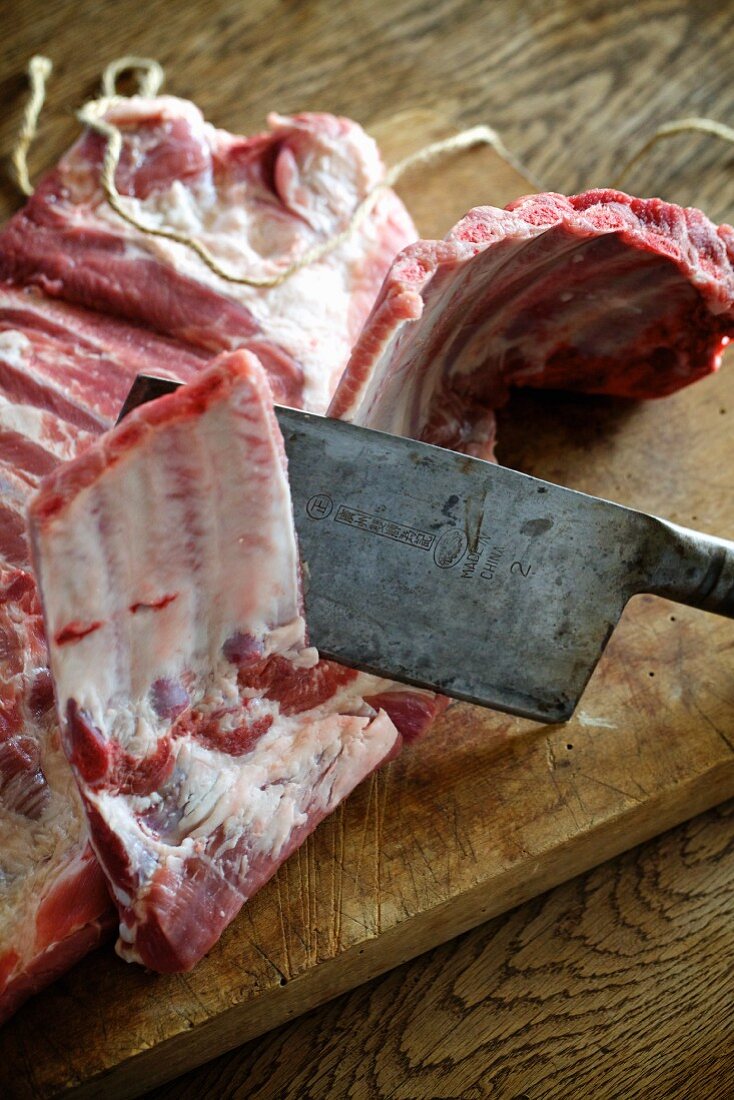 Raw pork ribs and a cleaver