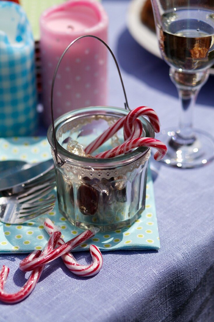 Zuckerstangen, bunte Kerzen und Drink auf einem Tisch