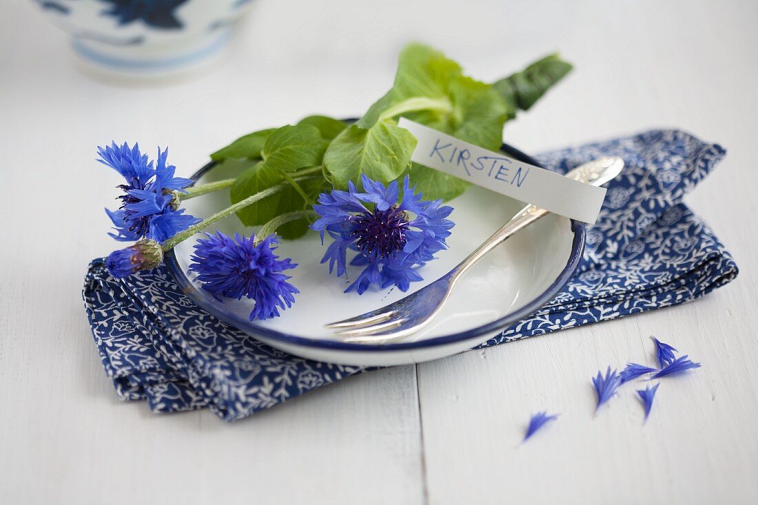 A place setting with cornflowers and a name card