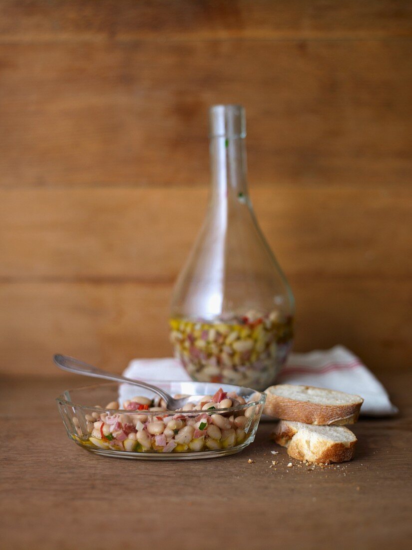 Pickled beans in a bottle, with slices of baguette