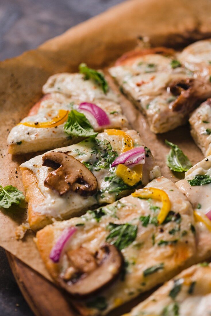 Vegetarische Pizza mit Champignons, Zwiebel, Paprika und frischem Basilikum