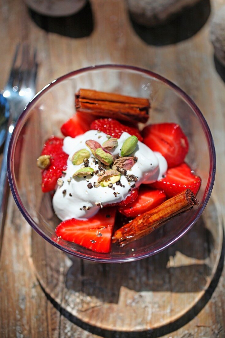 Strawberries with cream, pistachios and cinnamon sticks