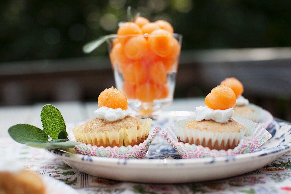 Muffins Topped with Melon Balls; On an Outdoor Table
