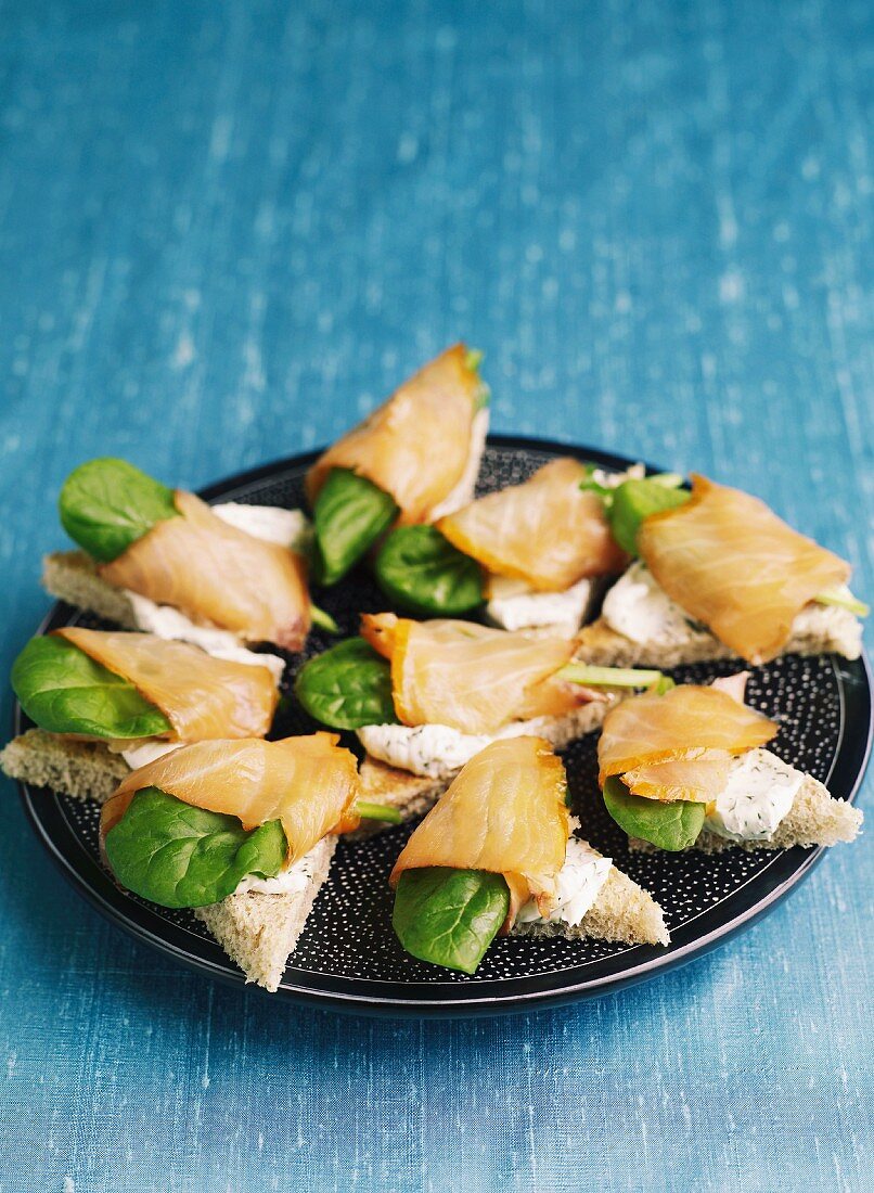 Canapés with cream cheese, smoked salmon and baby spinach