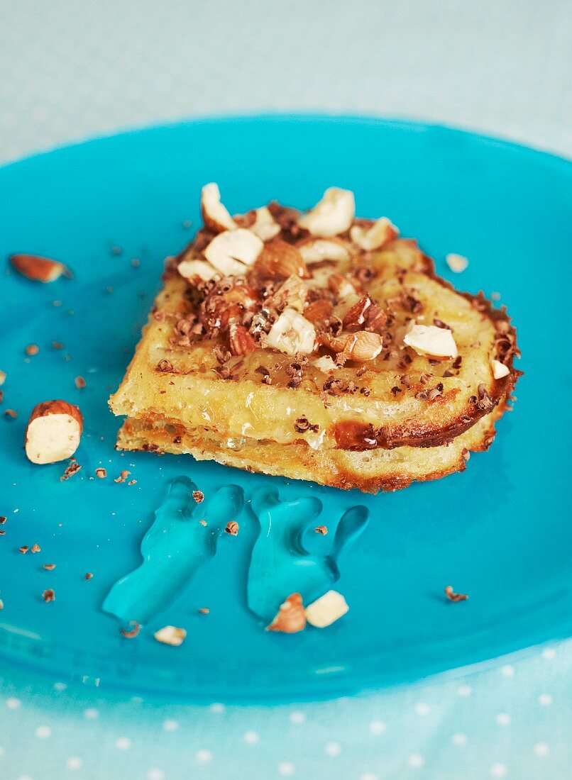 A heart-shaped waffle with hazelnuts, honey and chocolate