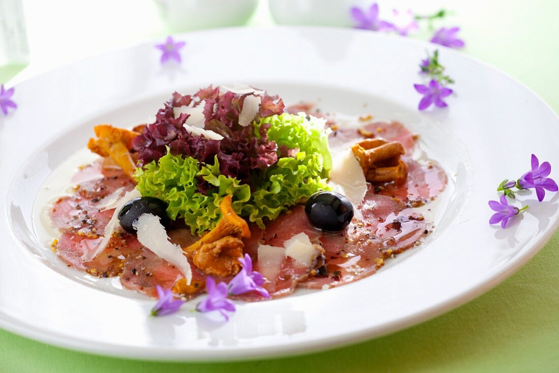Rindercarpaccio mit Pfifferlingen, Oliven, Parmesan und Salat