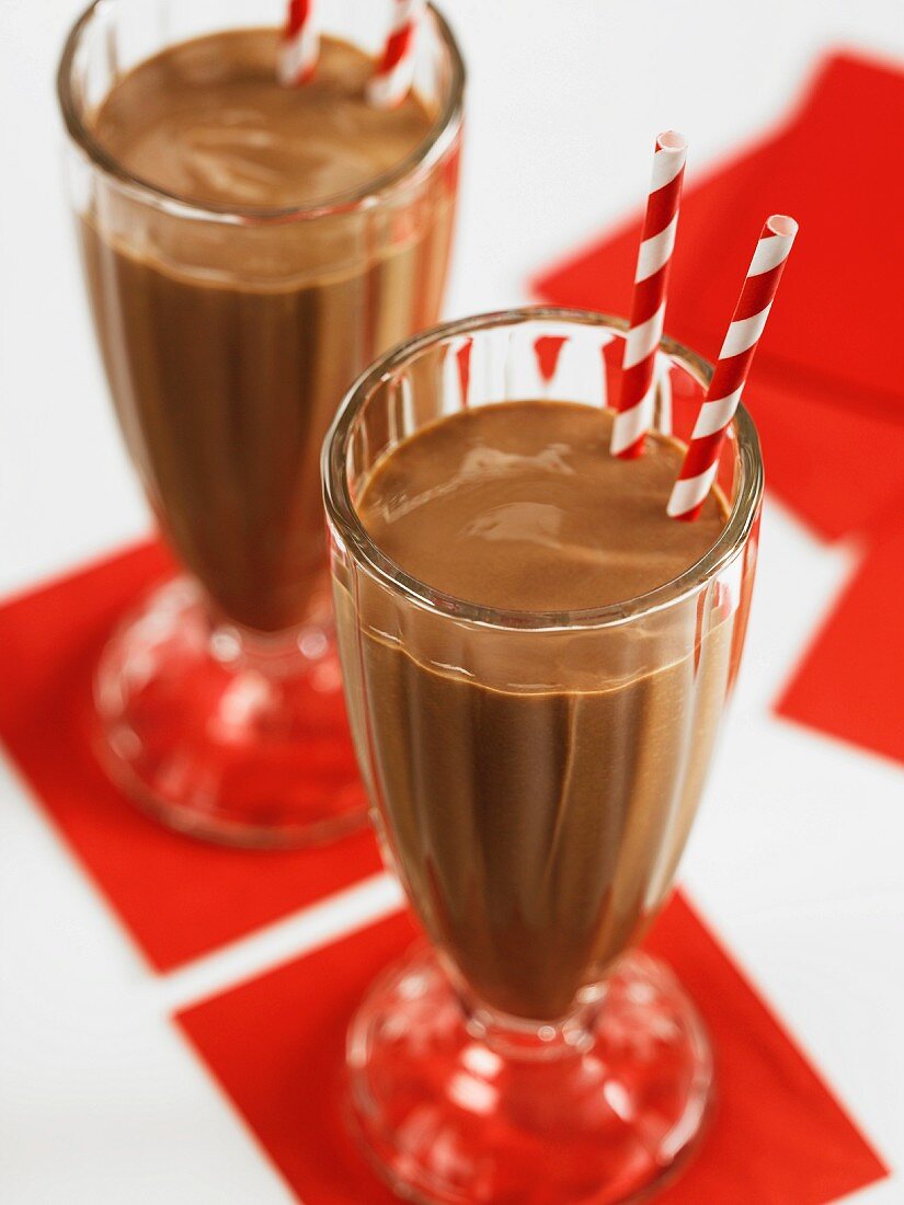 Chocolate milk shake in two glasses with drinking straws