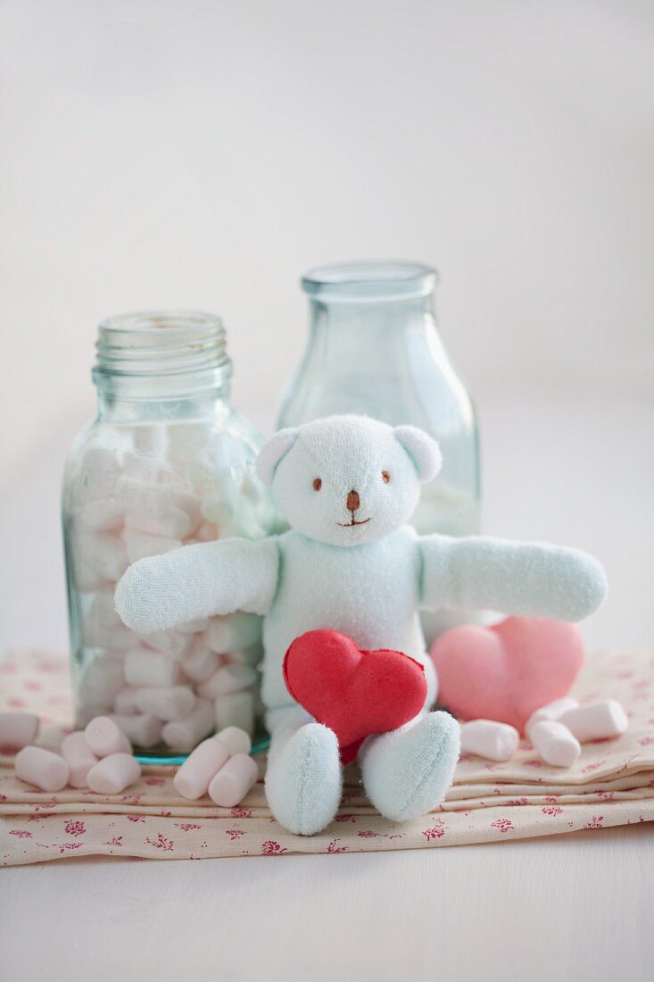 Heart-shaped strawberry and rose macaroons with marshmallows and a stuffed bear