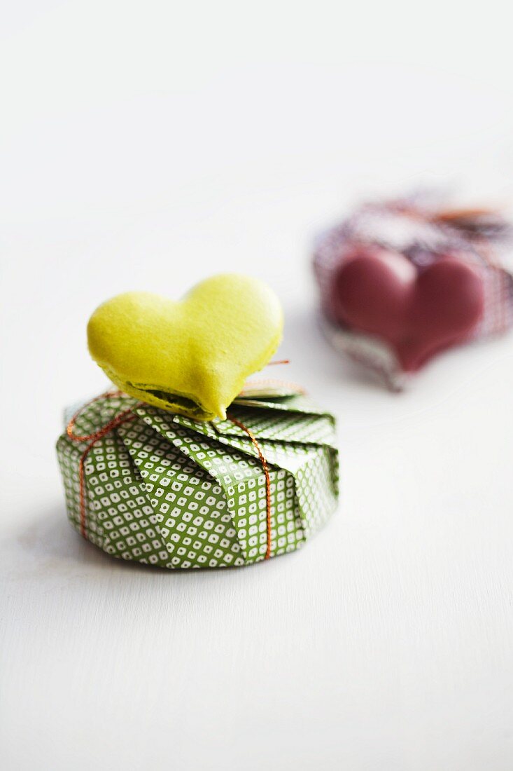 A heart-shaped lime macaroon on top of a present