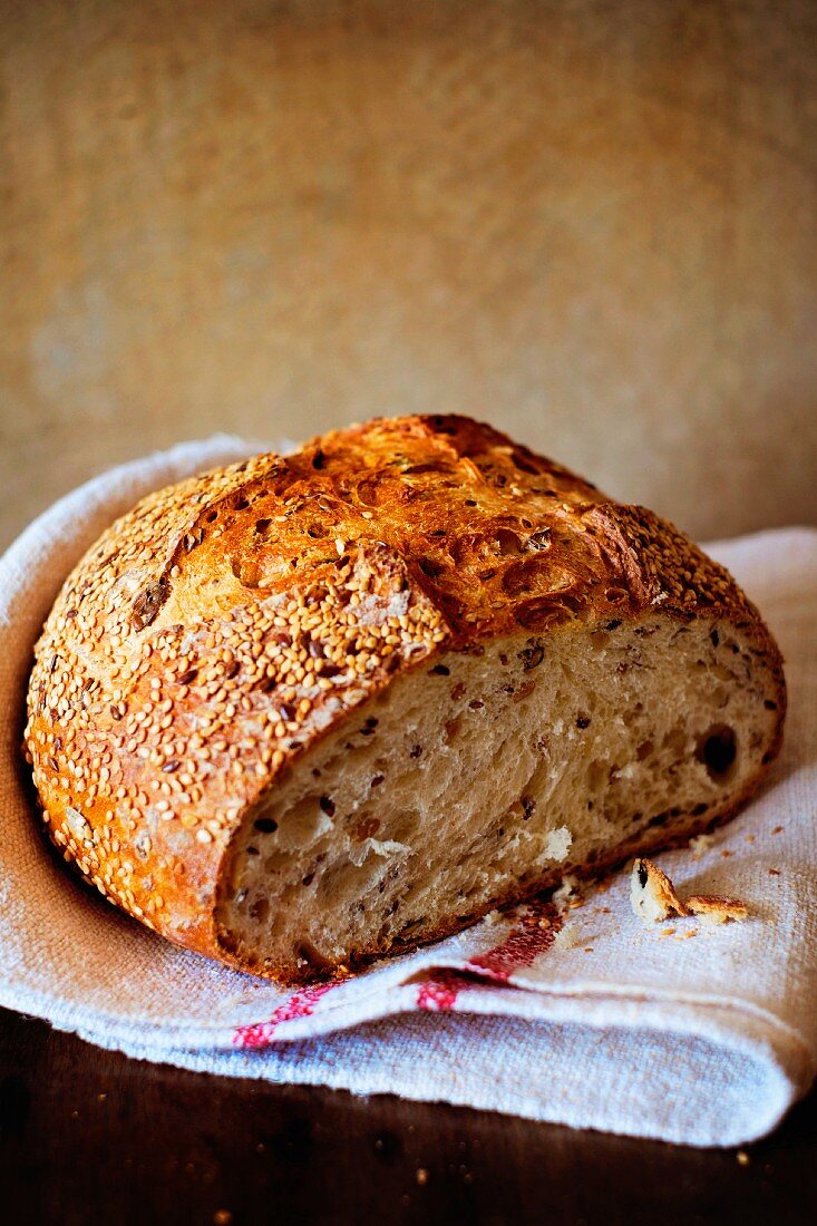 Seeded bread, sliced open, on a linen cloth