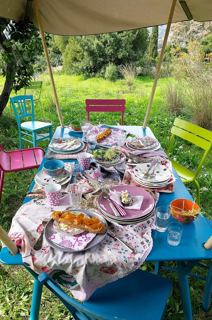 Gedeckter Tisch im Garten unter einem Sonnensegel