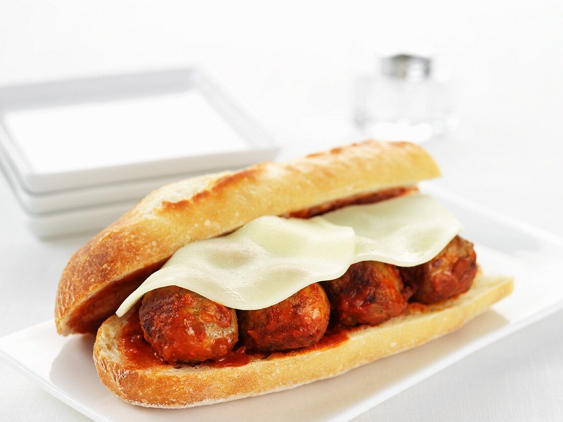 A sandwich with meatballs and Provolone cheese