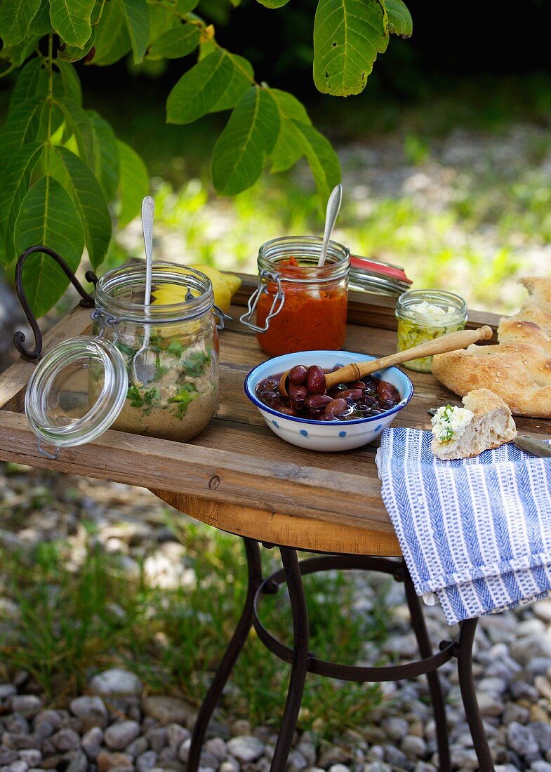 Grillfest mit Oliven, Fladenbrot, Feta und Aufstrichen (Griechenland)