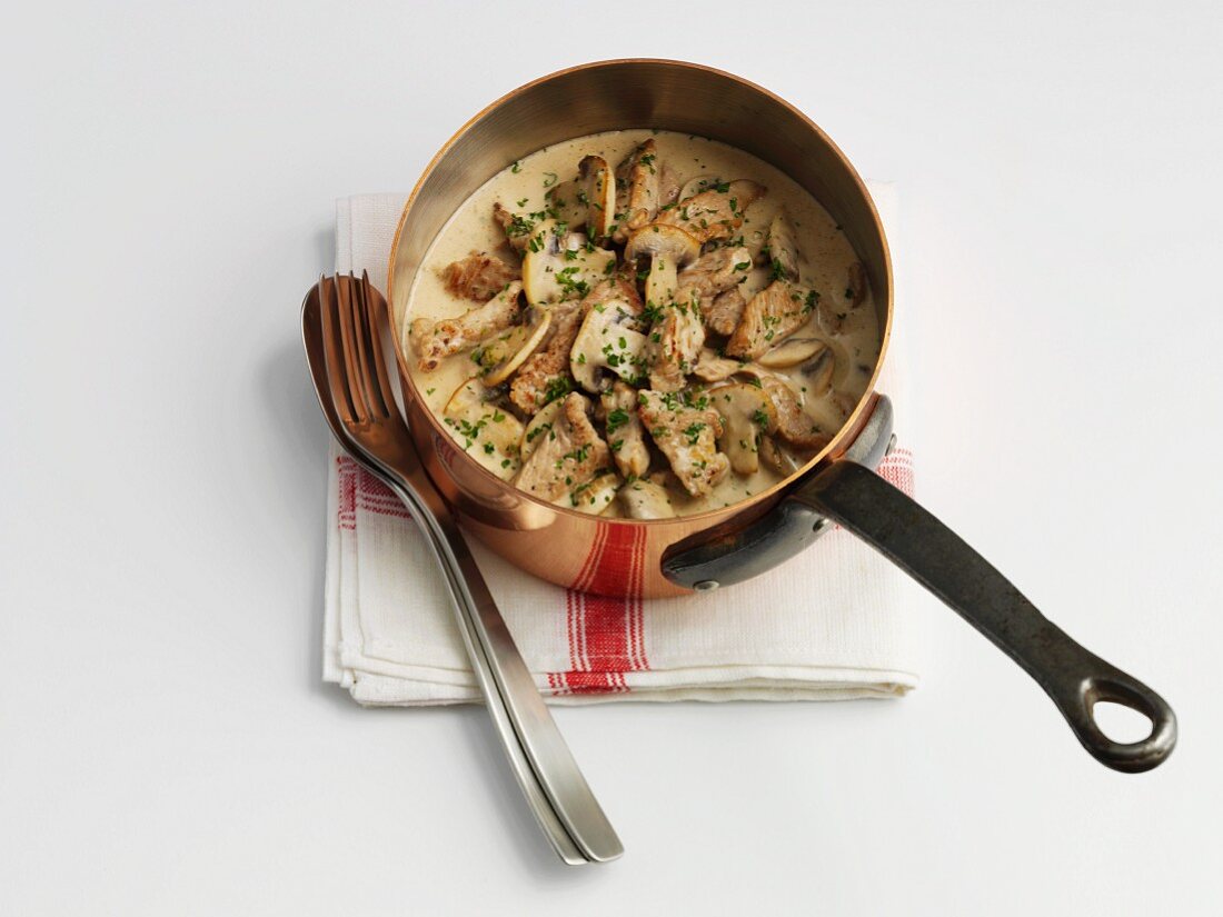 Zürcher Geschnetzeltes (Swiss dish from Zurich consisting of chopped veal, mushrooms and cream) in a copper saucepan