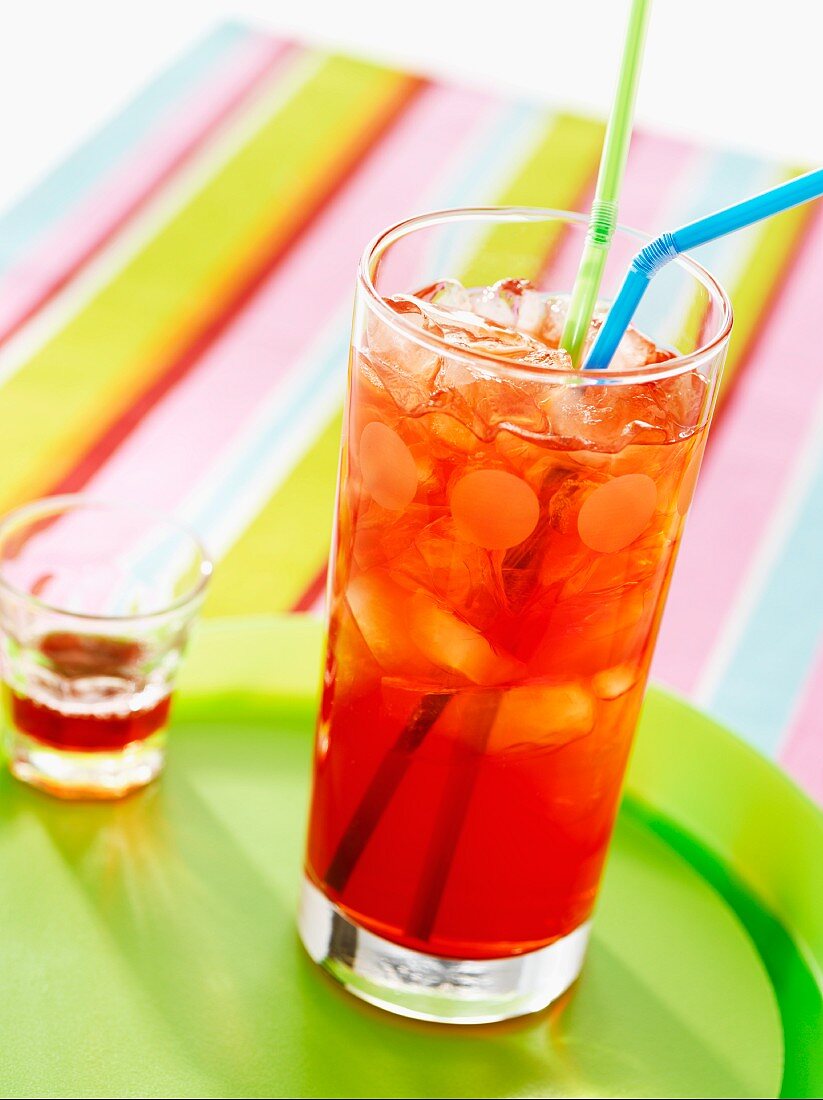 Fruit punch in a glass with drinking straws