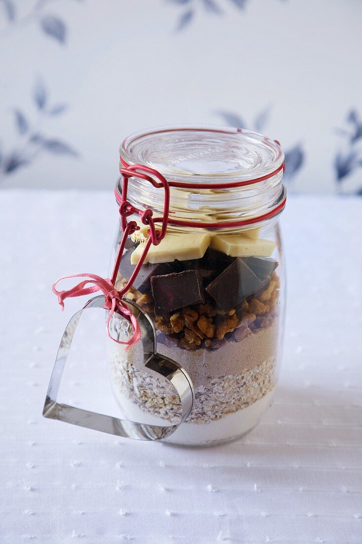 Trockene Zutaten für Chocolate Chunk Cookies in einem Einmachglas mit Herzausstecher
