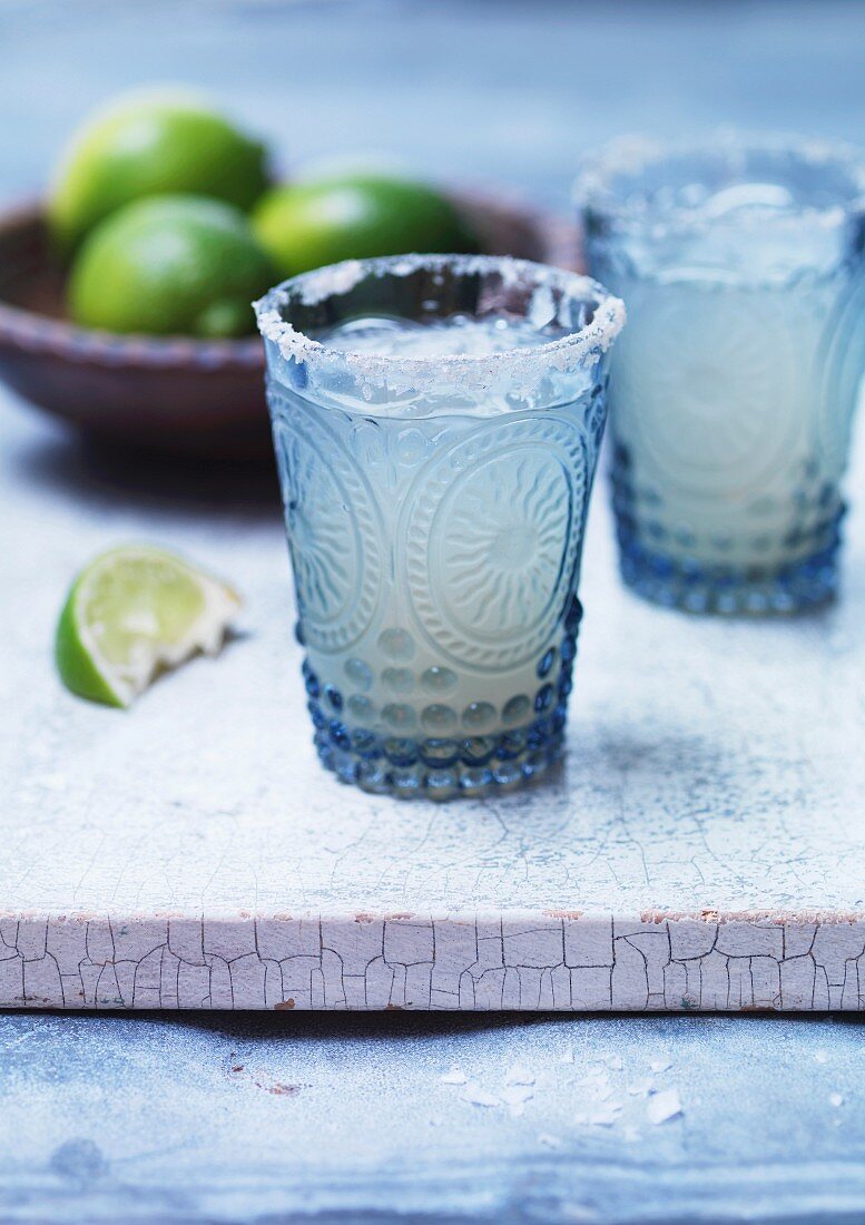Margaritas with lime juice in glasses with a salt rim
