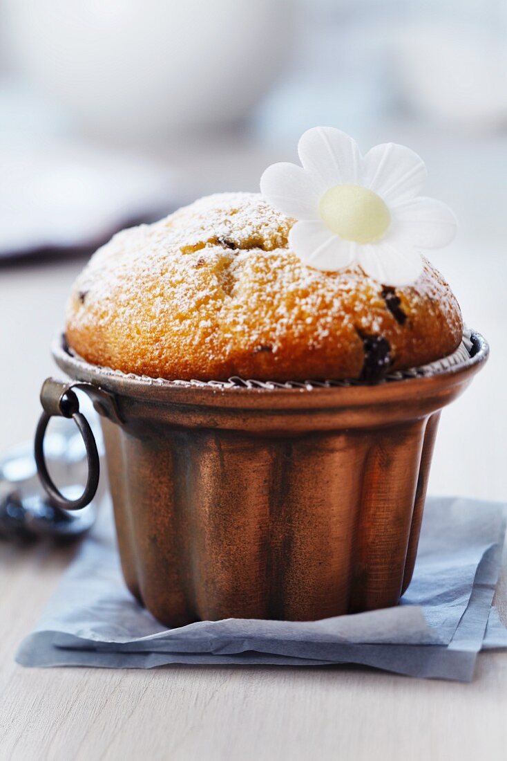 Muffin in copper cake mould decorated with edible paper flower