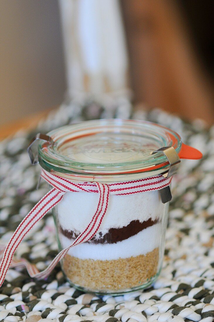 A preserving jar containing the dry ingredients for making chocolate biscuits