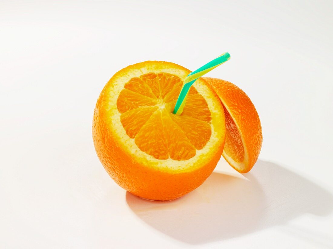 An orange, cut open, with a drinking straw