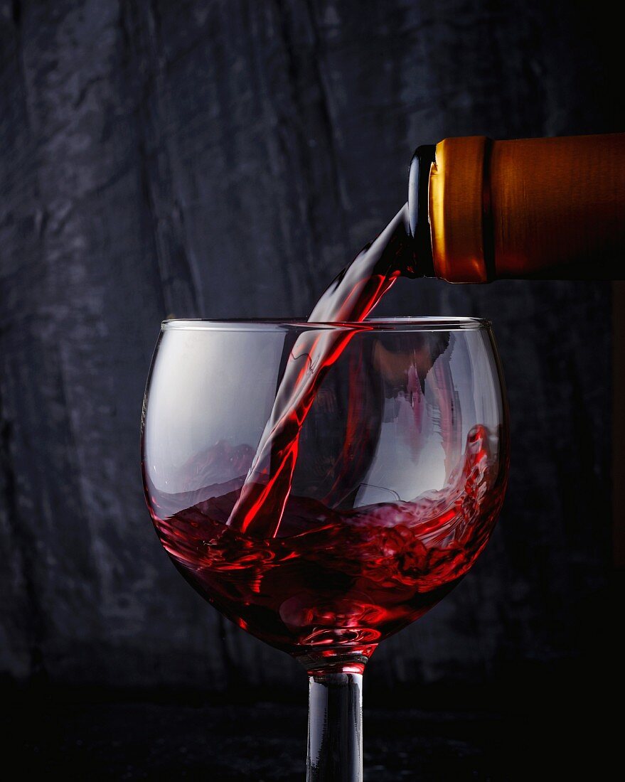 Pouring red wine into a glass