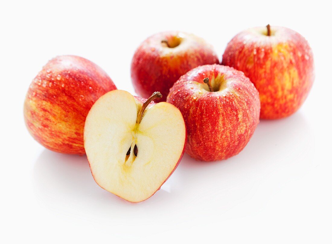 Several apples of the variety Gala Tenroy, whole and halved