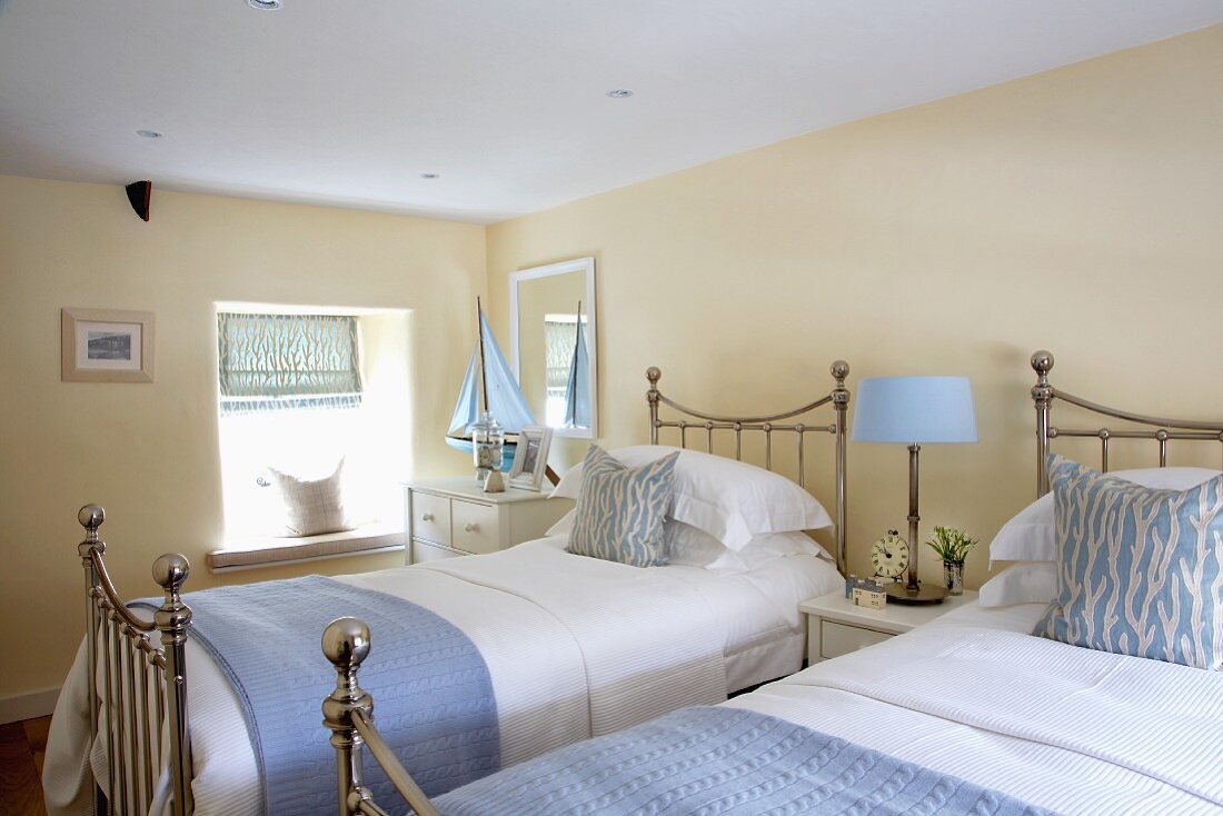 Cream bedroom with pale blue accessories combined with chrome country-house twin beds