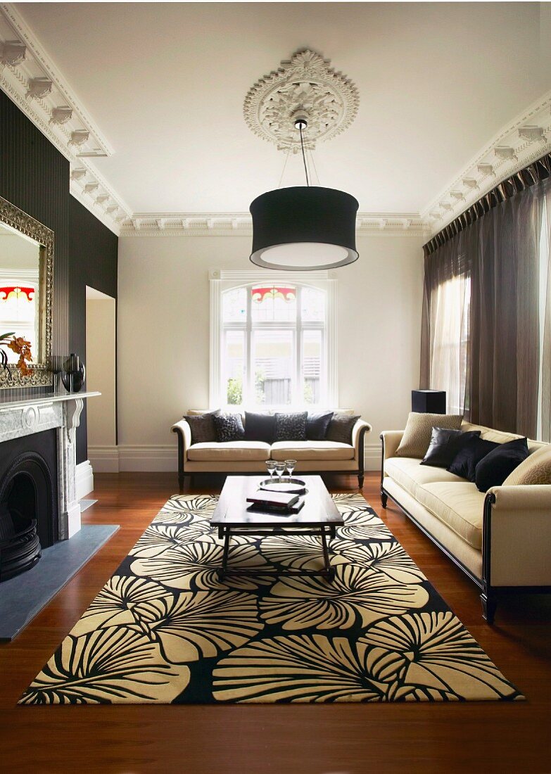 Tradtionelles Wohnzimmer mit schwarzweissem Blumen-Teppich und elegante Sofagarnitur