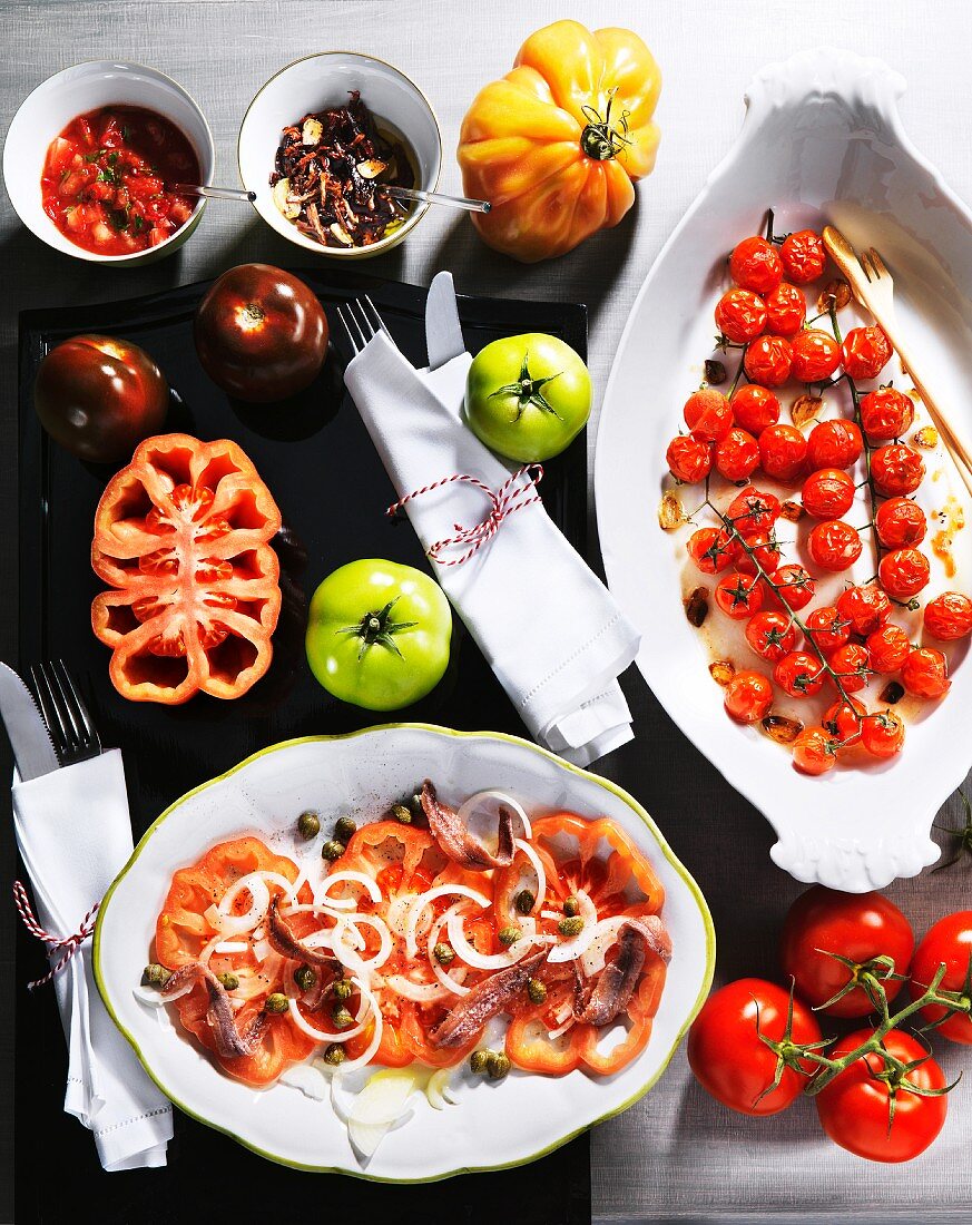 Verschiedene Tomatengerichte und frische Tomaten
