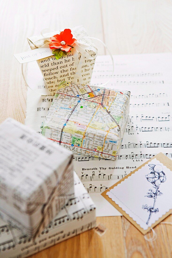 Presents wrapped imaginatively in pages of books, sheet music and old street maps