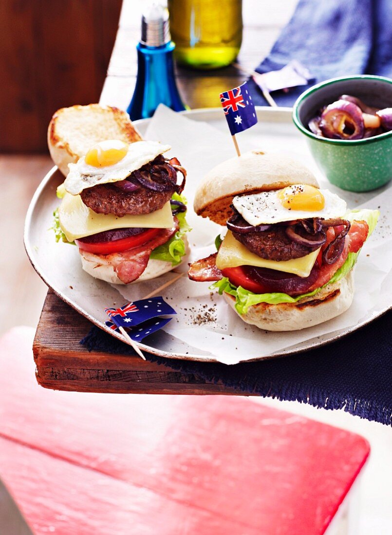 Mini bacon cheese burgers with vegetables, onions, fried quail's eggs and Australian flags