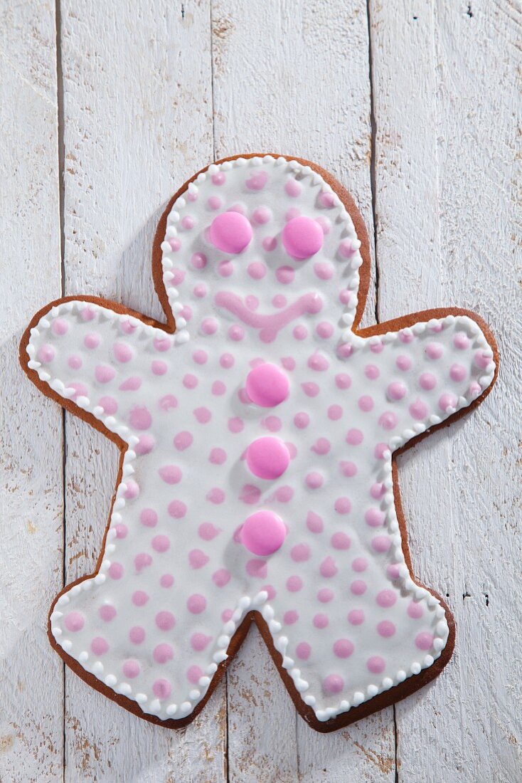 A gingerbread man decorated with pink dots