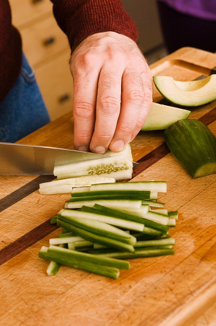 Man Slicing Cucumber into Sticks