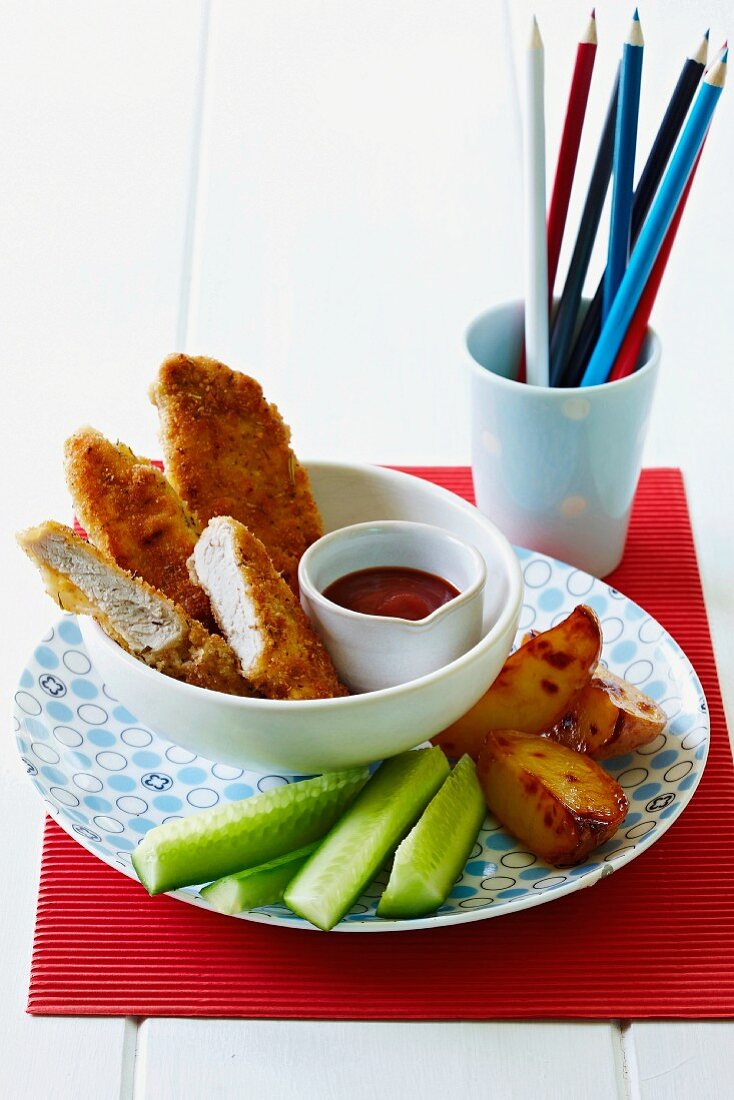 Panierte Schweineschnitzel mit Ketchup, Honigkartoffeln und Gurken